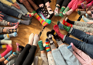 Nogi uczniów w kolorowych skarpetkach.