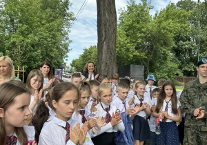 Grupa ludzi stoi na rondzie.