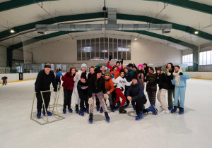 Grupa uczniów wraz z nauczycielami na lodowisku.